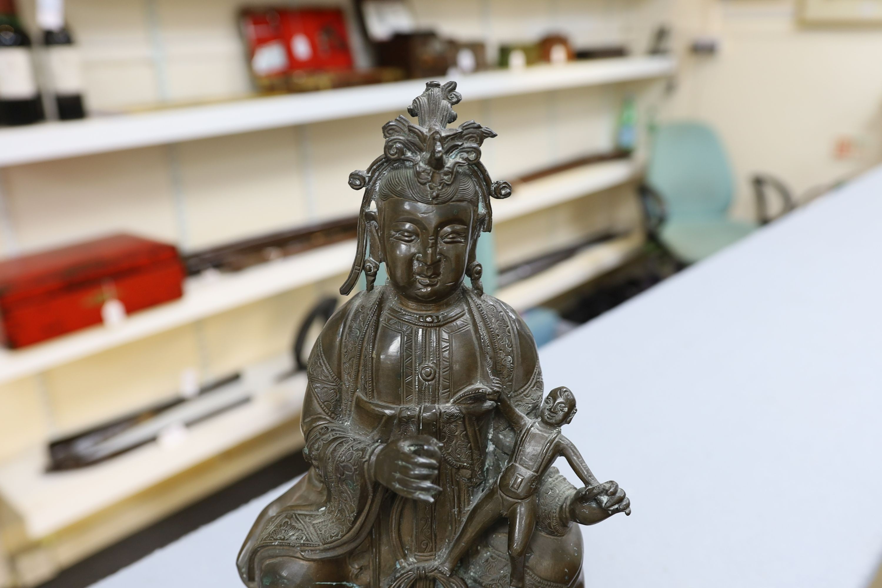 A large Chinese bronze group of Xi Wangmu and a child, late Ming dynasty, 31.5cm high excluding later wood stand